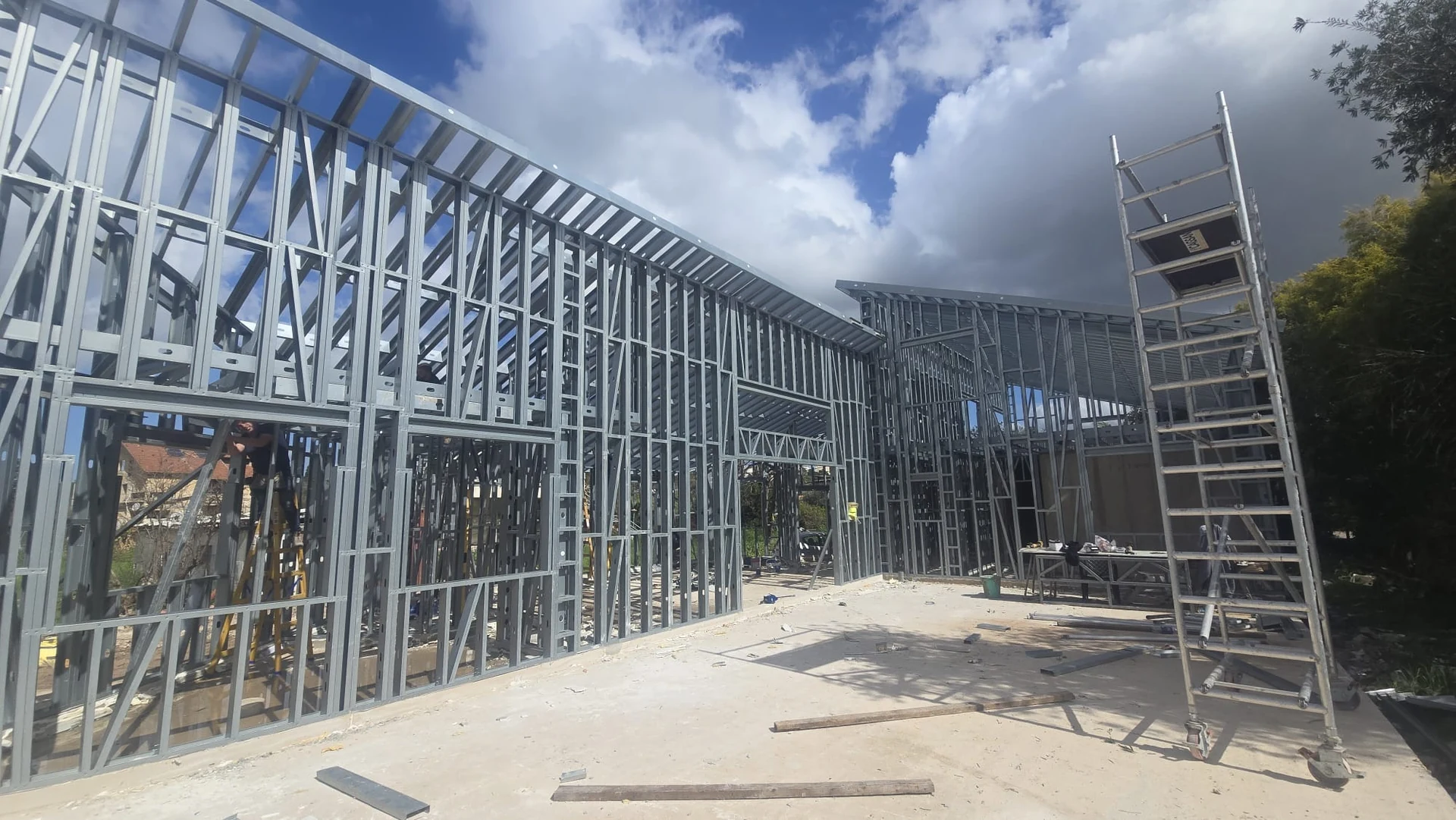 בניית בית פרטי רחב ידיים – קומה אחת גבוהה עם גגות משופעים לכיוונים שונים