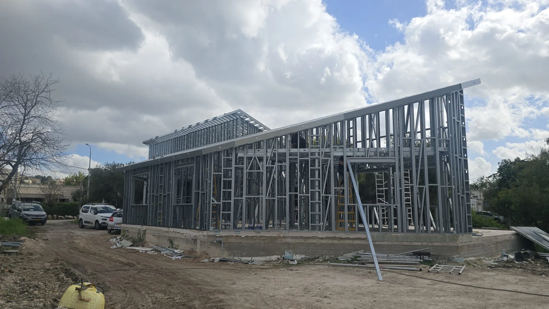 בניית בית פרטי רחב ידיים – קומה אחת גבוהה עם גגות משופעים לכיוונים שונים